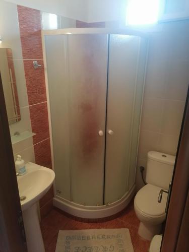 ein Badezimmer mit Dusche, Toilette und Waschbecken in der Unterkunft KALIPSO STUDIOs in Nikiti