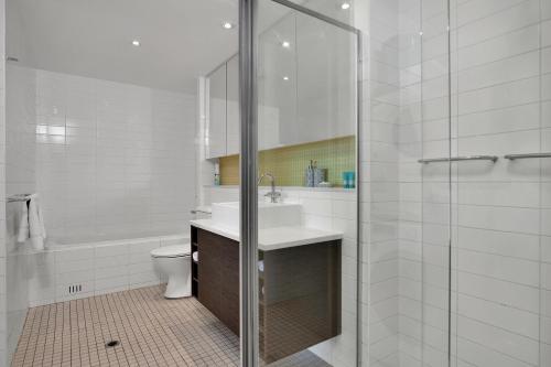 een badkamer met een douche, een wastafel en een toilet bij Sea and Park Deluxe Glenelg in Glenelg