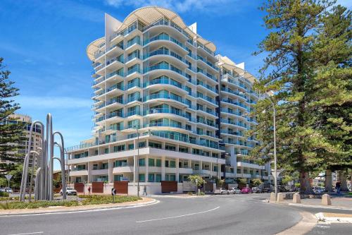 a large apartment building with a street in front of it at Sea and Park Deluxe Glenelg in Glenelg