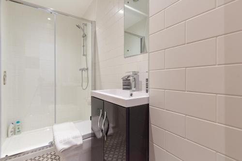 a white bathroom with a sink and a shower at Albion at the Level - 2 BD Flat in Brighton & Hove