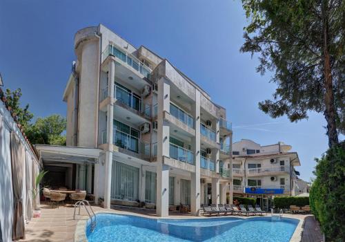 - un grand bâtiment avec une piscine en face dans l'établissement Jupiter 1 Family Hotel, à Balchik
