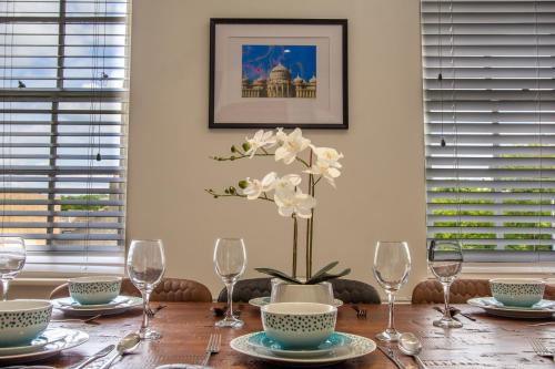 a dining room table with glasses and a vase of flowers at Albion at the Level - 2 BD Flat in Brighton & Hove