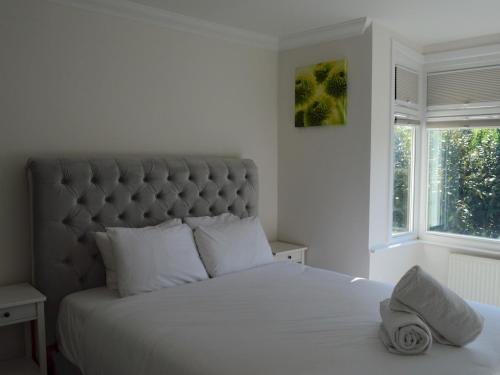een slaapkamer met een groot wit bed met een hoed erop bij Pass the Keys Gorgeous Maisonette in Bournemouth
