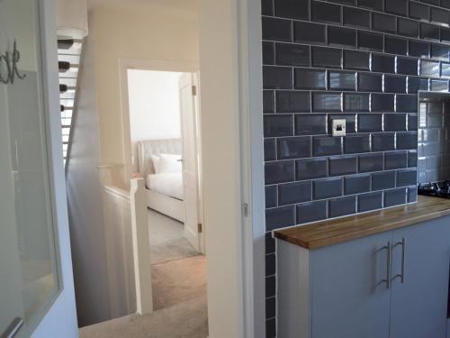 a kitchen with a blue tiled wall in a room at Pass the Keys Gorgeous Maisonette in Bournemouth