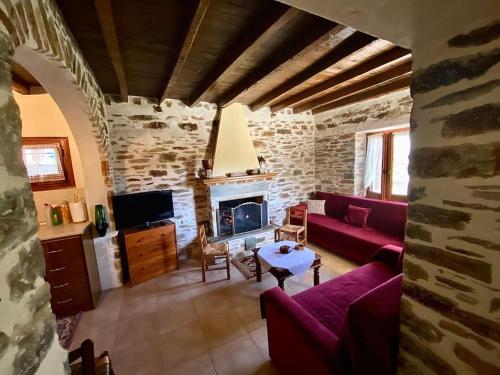 a living room with a red couch and a fireplace at Katerina's Guest House in Promírion