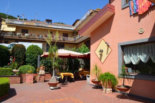 a building with a patio with plants and a table at Villa Hirschen in Zafferana Etnea