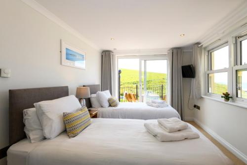 a bedroom with two beds and a window at Beachcombers Apartments in Newquay