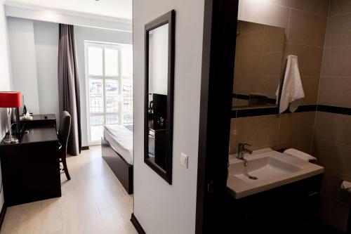 a bathroom with a sink and a mirror at Chagala Aktau Hotel in Aktau