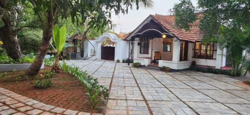 a house with a brick driveway in front of it at Kumarakom Tharavadu - A Heritage Hotel, Kumarakom By Perfect Stays in Kumarakom
