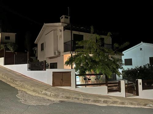a white building with a gate and a fence at Seaclusion Vacation Villa in Pomos