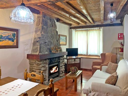 sala de estar con chimenea de piedra y sofá en Casa rural Álamo - Valle de El Paular, en Rascafría