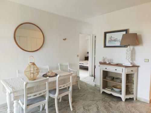 a white dining room with a table and a mirror at Eden Palladio Appt 2 ch front de mer accès direct à la plage in Saint-Raphaël