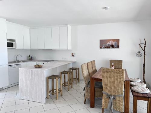 une cuisine avec des armoires blanches et une table et des chaises dans l'établissement On the beach, à Valras-Plage