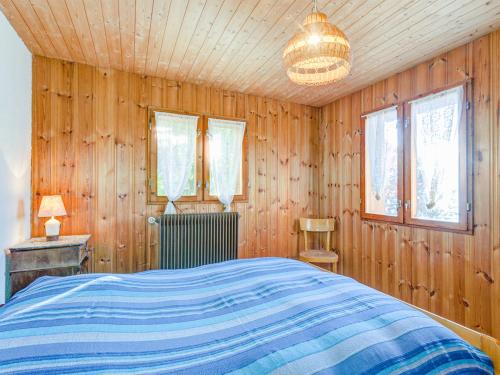 Schlafzimmer mit einem Bett sowie Holzwänden und -fenstern in der Unterkunft Chalet mit Saunabereich - CH 383.014 in Nendaz