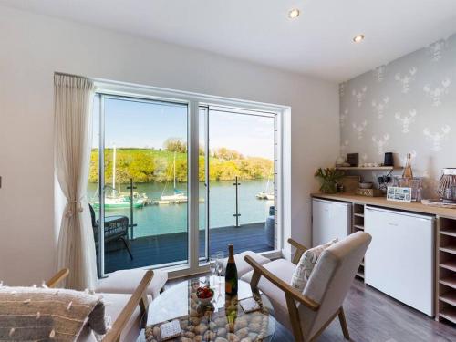 a living room with a kitchen and a large window at 1 The Boatyard - Water fronted, town location & parking for 2 cars in Kingsbridge