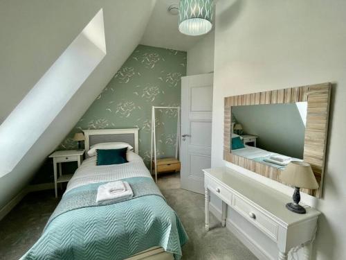 ein Schlafzimmer mit einem Bett und einem großen Spiegel in der Unterkunft 1 The Boatyard - Water fronted, town location & parking for 2 cars in Kingsbridge