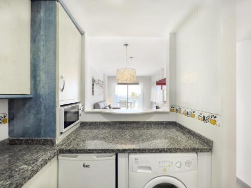 a kitchen with a washing machine and a sink at Apartamentos Hipocampos Calpe Rent Apart in Calpe