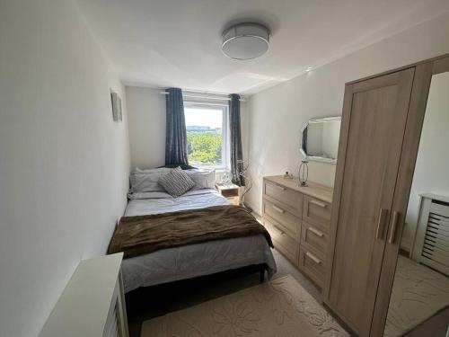 a bedroom with a bed and a dresser and a window at Chic 3 Bed in the heart of Chiswick in London