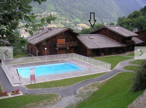une maison avec une piscine devant dans l'établissement Chalet Teddy Bear 3 Chambres, au coeur de St Gervais, à Saint-Gervais-les-Bains