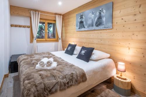- une chambre avec un grand lit et 2 serviettes dans l'établissement Chalet Teddy Bear 3 Chambres, au coeur de St Gervais, à Saint-Gervais-les-Bains