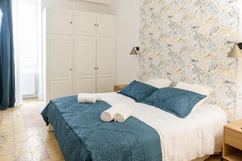1 dormitorio con 1 cama con toallas en La Tour Des Remparts, en Rochemaure