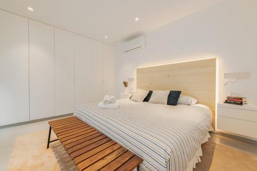 1 dormitorio con 1 cama grande y cabecero de madera en Fahana Las Canteras en Las Palmas de Gran Canaria