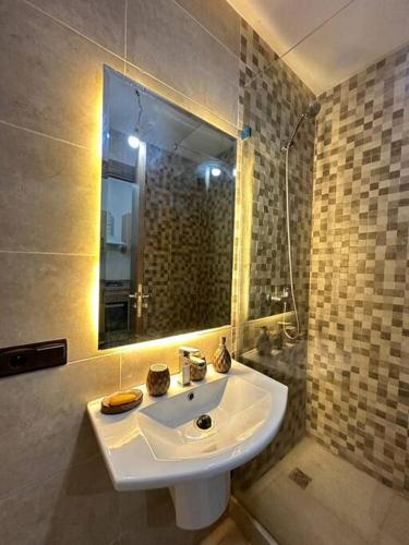 La salle de bains est pourvue d'un lavabo et d'un miroir. dans l'établissement appartement a Marrakech, à Marrakech