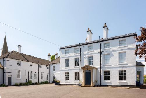 una fila de casas blancas con una iglesia en South Wing of Edwinstowe Hall, en Edwinstowe