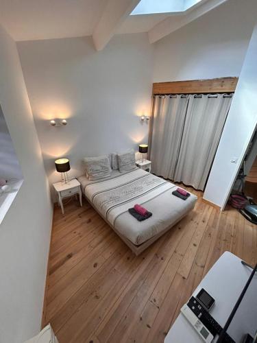 - une chambre avec un grand lit et du parquet dans l'établissement Villa fontaine, à Adissan