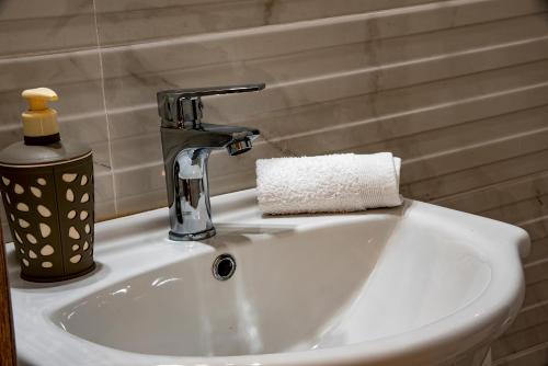 ein Waschbecken mit einem Wasserhahn und einem Handtuch in der Unterkunft Comfort House Mimosa 1 in Palekastro