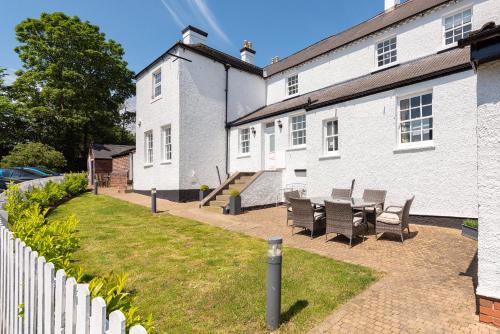 a house with a table and chairs in the yard at South Wing of Edwinstowe Hall in Edwinstowe