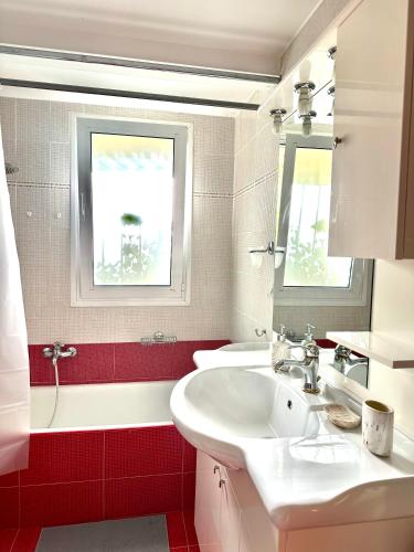 Kallikratis Apartment Near Athens Airport في سباتا: حمام مع حوض أبيض وبلاط احمر