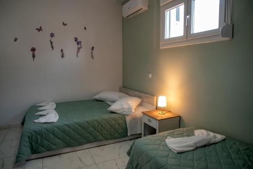 2 Einzelbetten in einem Zimmer mit Fenster in der Unterkunft Comfort House Mimosa 1 in Palekastro