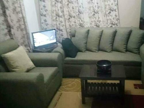 uma sala de estar com um sofá e uma mesa com um computador portátil em HMH Family Villa in Mexico, Pampanga em Mexico
