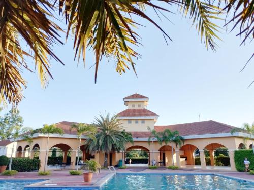 um edifício com piscina e palmeiras em HMH Family Villa in Mexico, Pampanga em Mexico