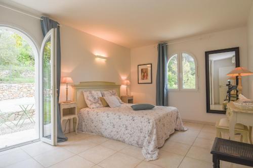 1 dormitorio con 1 cama y 2 ventanas en Villa SULIS en Lorgues