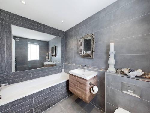 a bathroom with a tub and a sink and a bath tub at Paddlers View - Luxurious 2 bed, hot tub. Town centre, water views in Kingsbridge