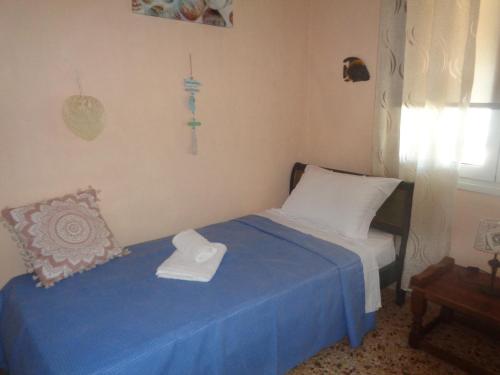a small bedroom with a blue bed and a window at SeaShell apartment Sea View, Castle View 200metres from the Beach in Sitia