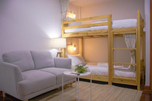 a living room with a couch and bunk beds at Home Story Hostel Chiang Mai in Chiang Mai