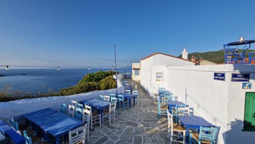 a row of tables and chairs with the ocean in the background at Peppermint Bay in Skopelos Town
