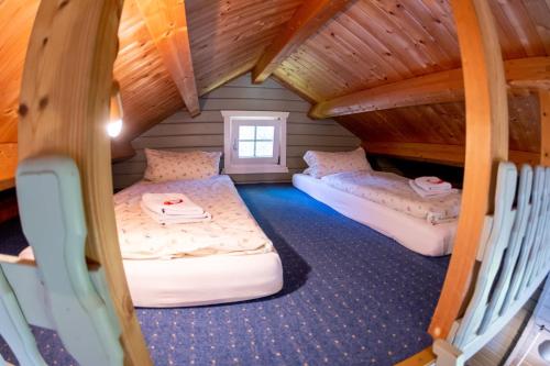 a room with two beds in a attic at Kummerower Hof in Neuzelle