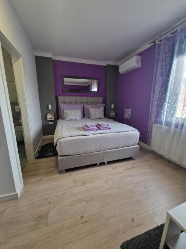 um quarto com uma cama grande e paredes roxas em Apartment Mavero-Free Private Parking em Zagreb