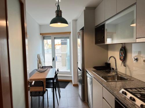 a kitchen with a sink and a table with chairs at Oasis beach apartment in Figueira da Foz