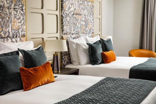 a hotel room with two beds and a lamp at The Municipal Hotel Liverpool - MGallery in Liverpool