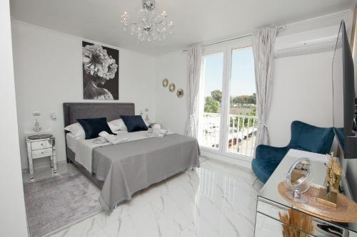 a white bedroom with a bed and a window at Katja Malo Misto in Zadar