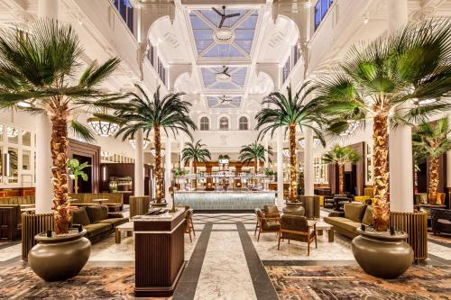 a lobby of a hotel with palm trees at The Municipal Hotel Liverpool - MGallery in Liverpool