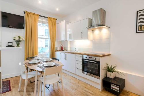 eine Küche und ein Esszimmer mit einem Tisch und Stühlen in der Unterkunft Camden Town Duplex in London