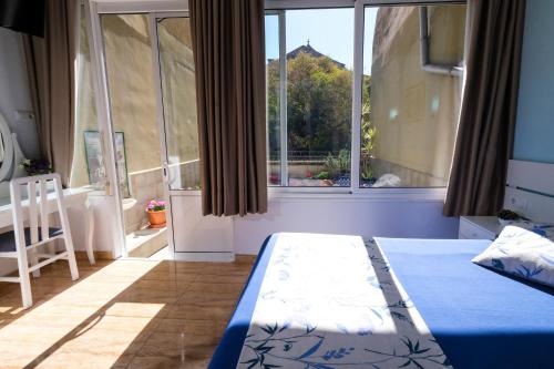 a bedroom with a bed and a large window at Hostal Ramos in Barcelona