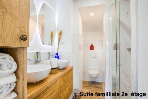 La salle de bains blanche est pourvue d'un lavabo et d'une douche. dans l'établissement Résidence LA VAGUE- 4 appartements Grand Confort -Vue mer - 2 à 6 personnes, à Houlgate