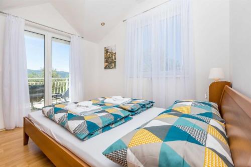 a bedroom with two beds and a large window at Holiday Home OLIVE GARDEN in Brzac